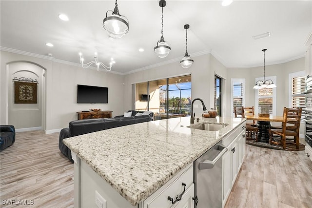 kitchen featuring stainless steel dishwasher, a notable chandelier, a sink, and light wood-style flooring