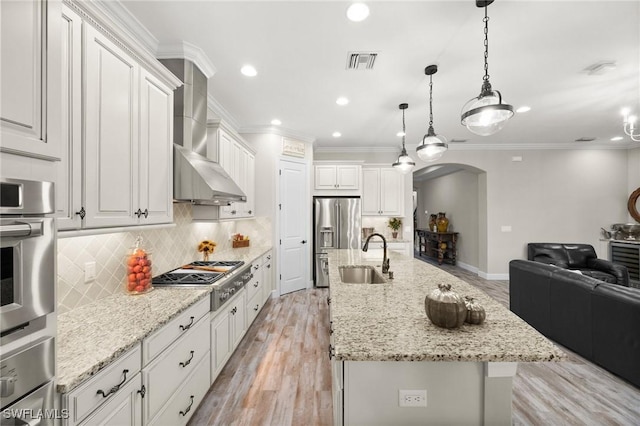 kitchen with visible vents, appliances with stainless steel finishes, arched walkways, a sink, and open floor plan
