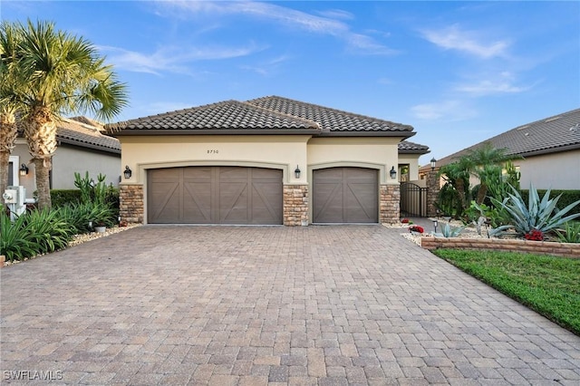 view of front of property with a garage, decorative driveway, stucco siding, and stone siding