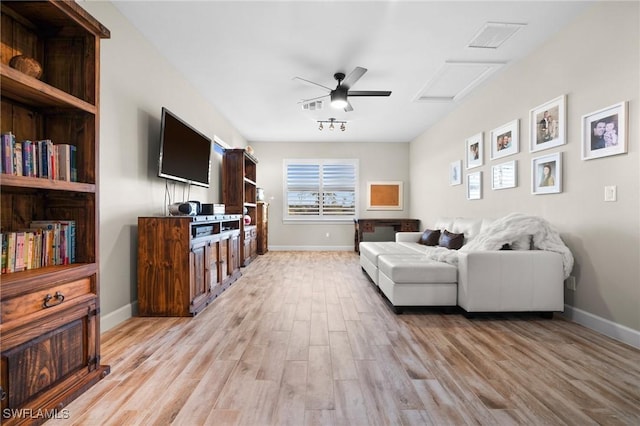 living room with baseboards, visible vents, light wood-style flooring, and attic access