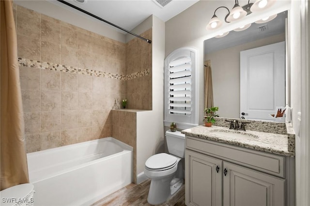 full bath featuring vanity, shower / tub combo with curtain, visible vents, wood finished floors, and toilet