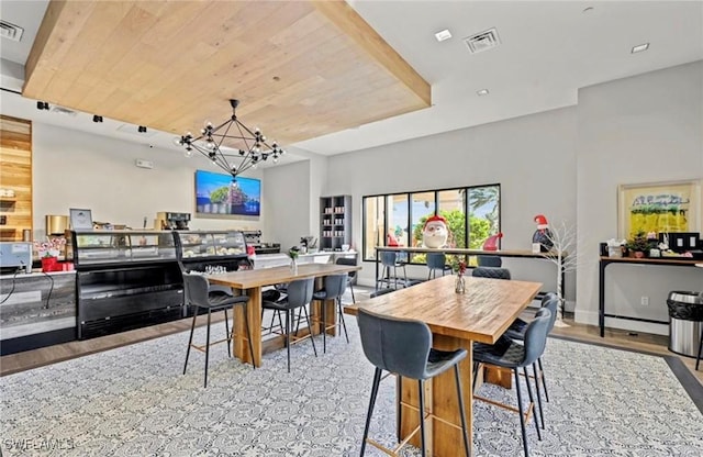 dining room featuring an inviting chandelier, wood finished floors, and visible vents