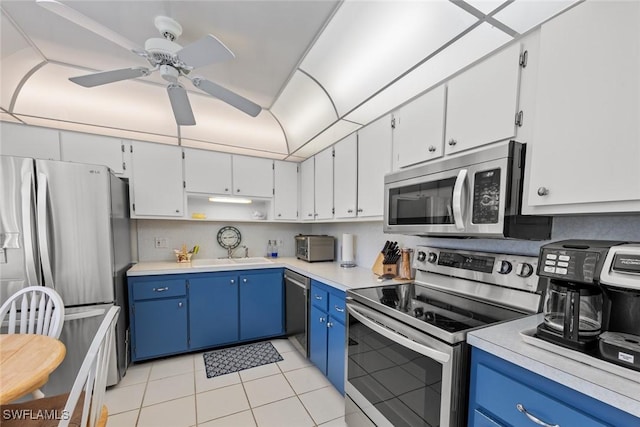 kitchen featuring appliances with stainless steel finishes, blue cabinetry, and white cabinets