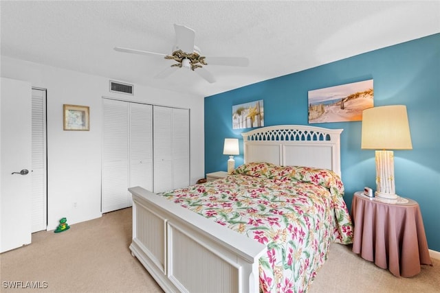 bedroom with light carpet, a textured ceiling, and ceiling fan