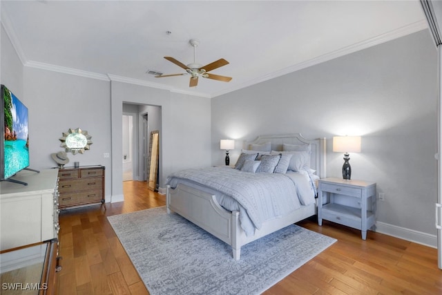 bedroom featuring ceiling fan, ornamental molding, and light wood-type flooring