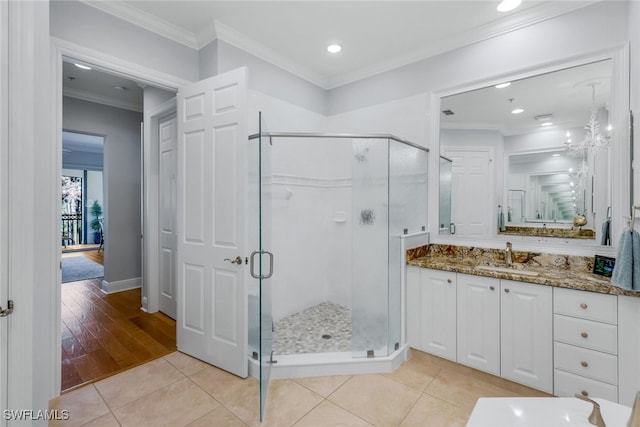 bathroom with ornamental molding, tile patterned floors, a shower with shower door, and vanity