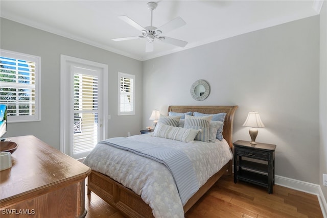 bedroom with crown molding, ceiling fan, wood-type flooring, and multiple windows