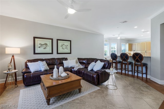 tiled living room featuring crown molding and ceiling fan