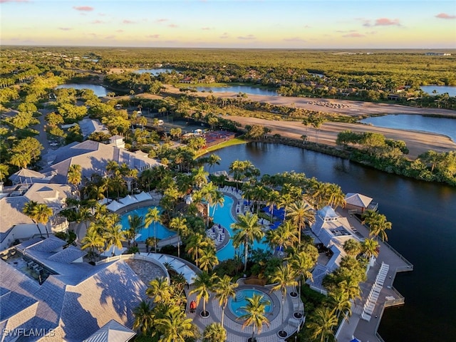 aerial view at dusk featuring a water view