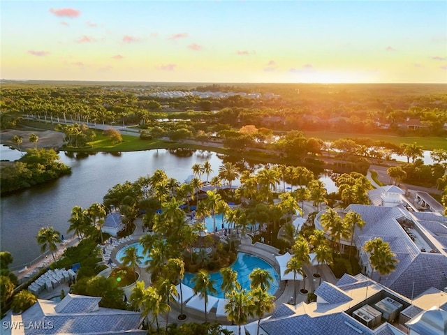 aerial view at dusk featuring a water view