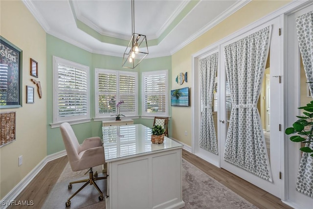 office space featuring a tray ceiling, ornamental molding, french doors, and light wood-type flooring