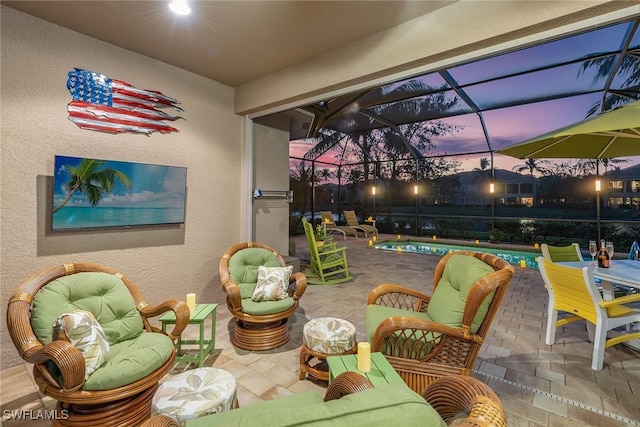 patio terrace at dusk featuring a lanai