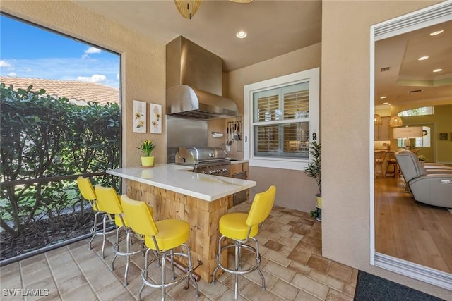 kitchen featuring range hood, kitchen peninsula, and a breakfast bar