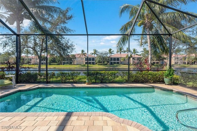 view of swimming pool with a lanai and a water view