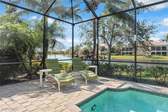 view of pool featuring a patio, a water view, and glass enclosure