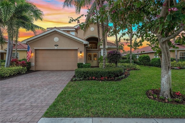 mediterranean / spanish house with a garage and a lawn