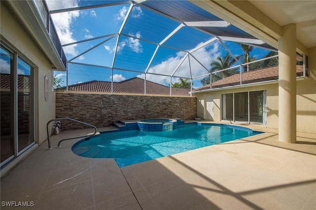 view of pool with a patio area, glass enclosure, and an in ground hot tub