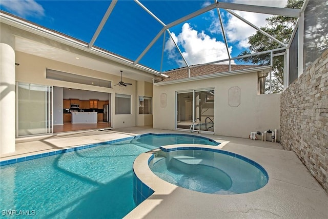 view of swimming pool featuring a patio, glass enclosure, and an in ground hot tub