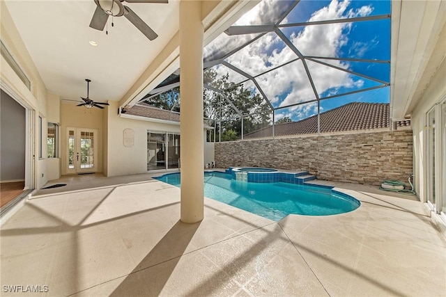 view of pool with ceiling fan, a patio area, glass enclosure, and an in ground hot tub