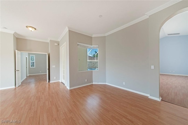 spare room with ornamental molding, vaulted ceiling, and light hardwood / wood-style flooring