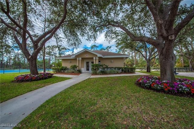 ranch-style home with tennis court, a front yard, and french doors