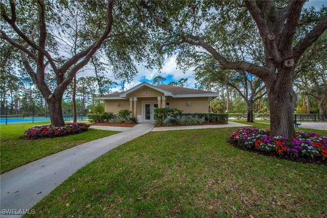 ranch-style house with tennis court, a front yard, and french doors