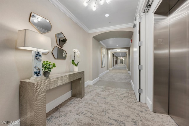 hall featuring arched walkways, elevator, ornamental molding, and carpet