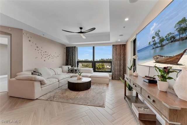 living area featuring a raised ceiling, a ceiling fan, and recessed lighting