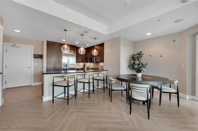 dining area with sink and light parquet flooring