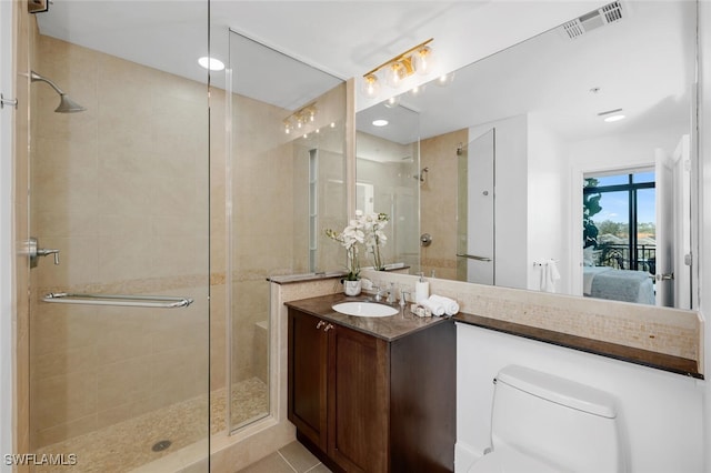 ensuite bathroom featuring a stall shower, toilet, and vanity