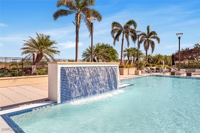 community pool featuring fence and a patio area