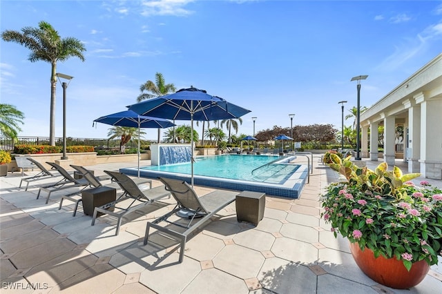 community pool with a patio and fence