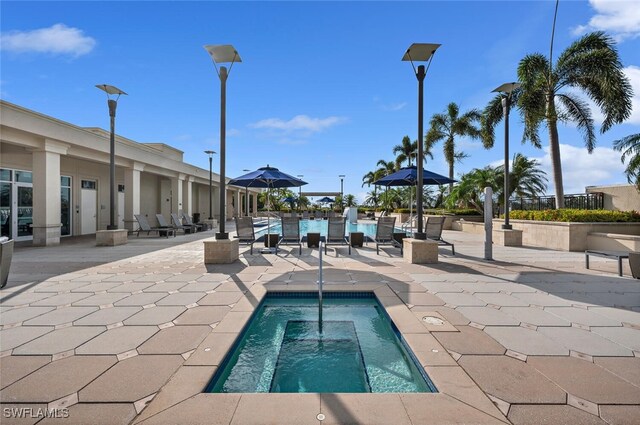 view of pool with an in ground hot tub and a patio area