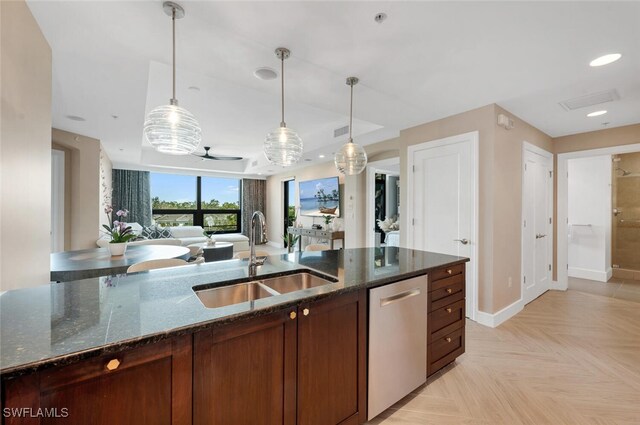 kitchen featuring light parquet flooring, dishwasher, sink, and dark stone countertops