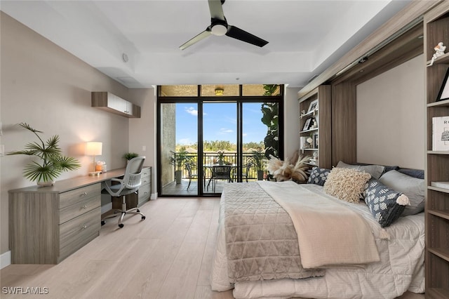 bedroom featuring floor to ceiling windows, a desk, access to exterior, light wood-type flooring, and ceiling fan