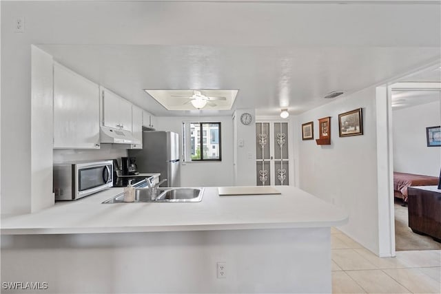 kitchen with white cabinetry, sink, light tile patterned floors, kitchen peninsula, and stainless steel appliances