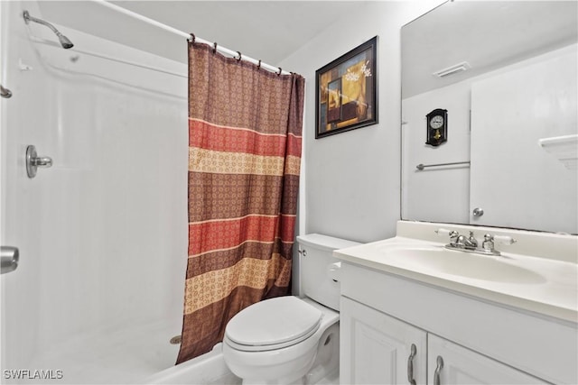 bathroom featuring vanity, curtained shower, and toilet