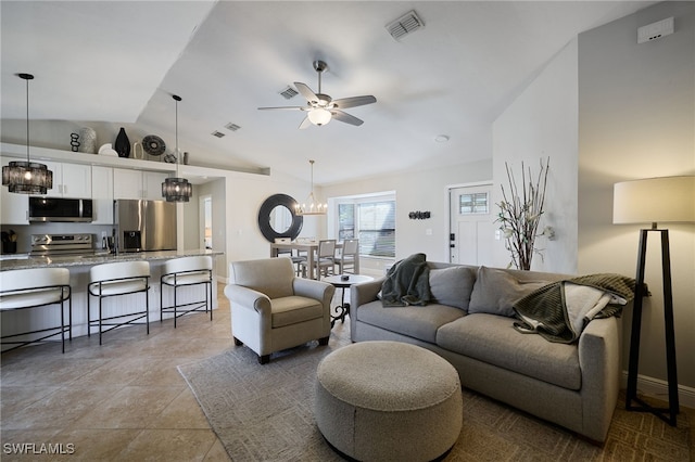 living room featuring ceiling fan with notable chandelier and vaulted ceiling