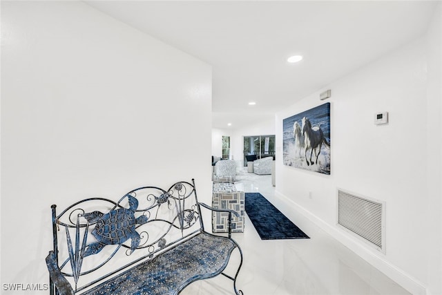 hall featuring baseboards, visible vents, and recessed lighting