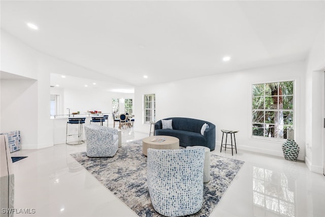 living room with lofted ceiling, baseboards, and recessed lighting