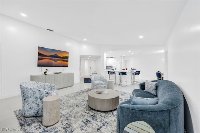 living area featuring recessed lighting, visible vents, and baseboards