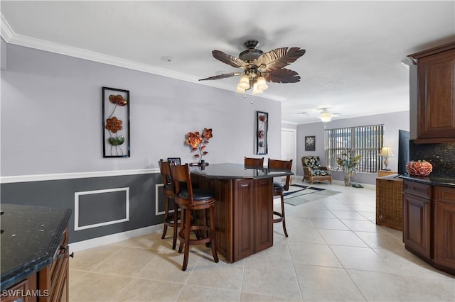 interior space with crown molding, ceiling fan, and bar