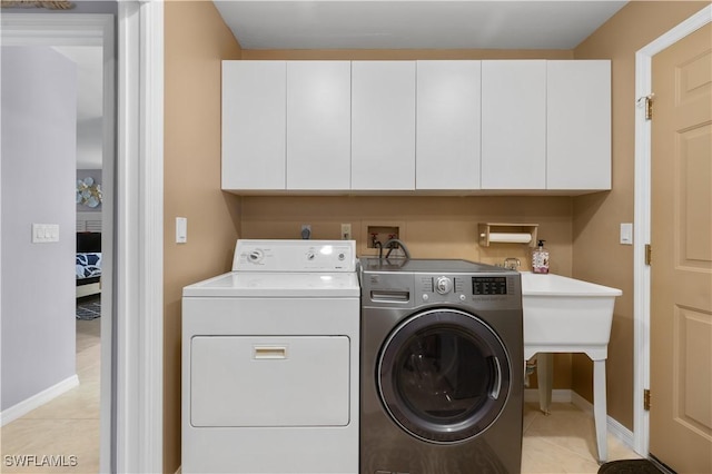 laundry room with cabinets, separate washer and dryer, and light tile patterned floors