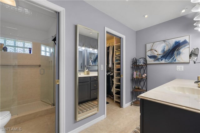 bathroom featuring tile patterned floors, vanity, toilet, and an enclosed shower