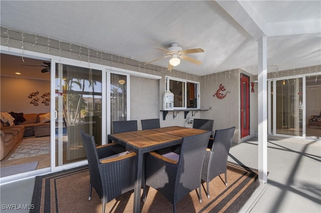 sunroom with ceiling fan and beam ceiling