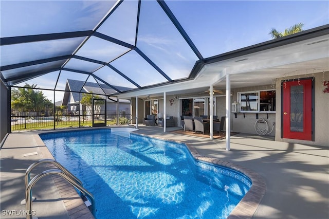 view of swimming pool featuring ceiling fan, glass enclosure, and a patio area