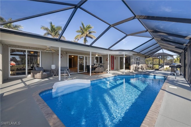 view of swimming pool with a patio, ceiling fan, and glass enclosure