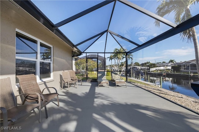 view of patio / terrace with a water view, glass enclosure, and a boat dock