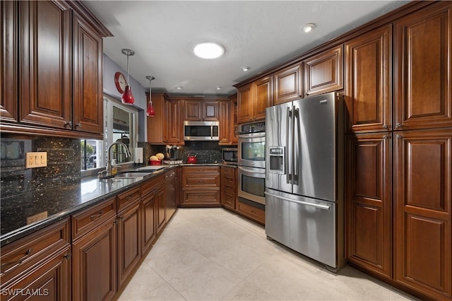 kitchen with sink, backsplash, dark stone counters, hanging light fixtures, and stainless steel appliances