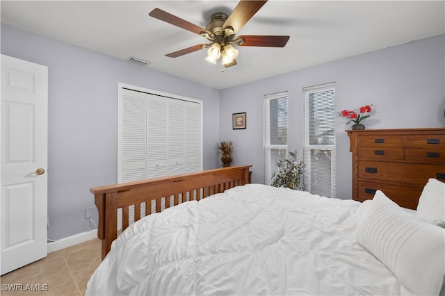 bedroom featuring light tile patterned floors, a closet, and ceiling fan